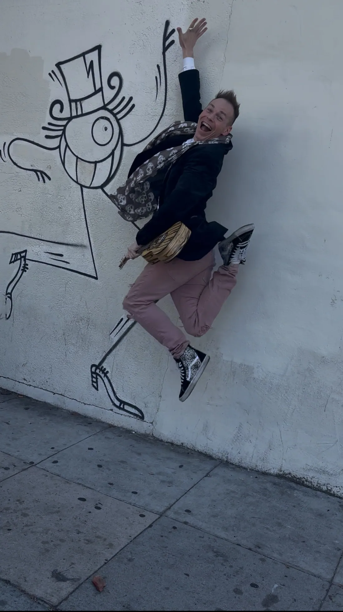 Ryan Today jumping to high-five a painted figure on a wall